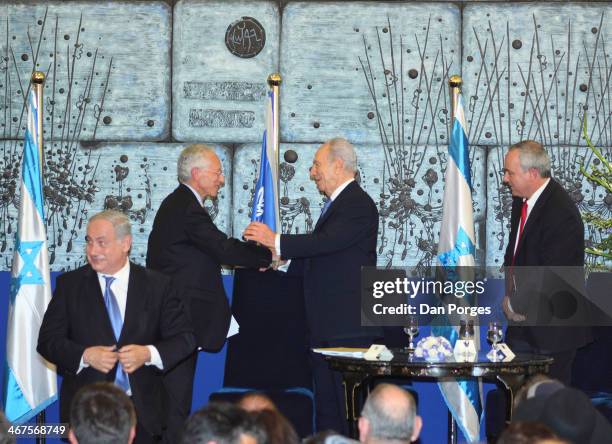 At a ceremony to re-nominate Professor Stanley Fischer to a second term as Governor of the Bank of Israel, Fischer smiles and shakes hands with...