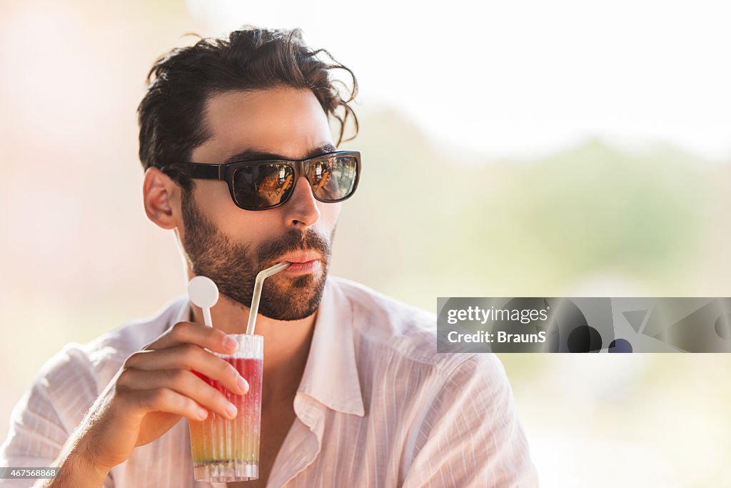 Uomo godendo all'aperto, mentre per bere i cocktail.