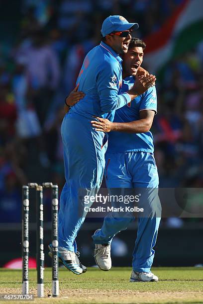 Suresh Raina of India congratulates Umesh Yadav of India as he celebrates taking the wicket of Aaron Finch of Australia during the 2015 Cricket World...