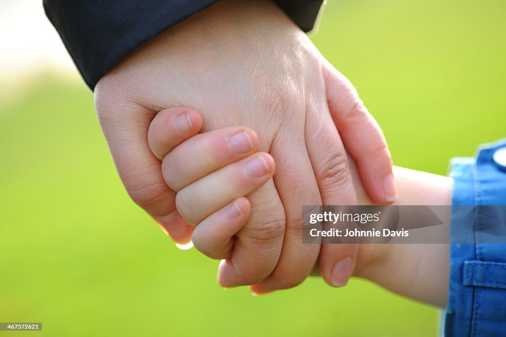 Close up of mother and daughter holding hands