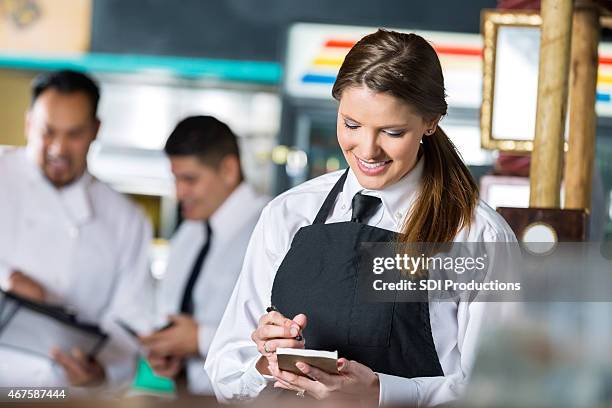 happy young waitress preparing check for customer in tex-mex restaurant - report fun stock pictures, royalty-free photos & images