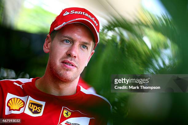Sebastian Vettel of Germany and Ferrari speaks with members of the media in the paddock during previews to the Malaysia Formula One Grand Prix at...