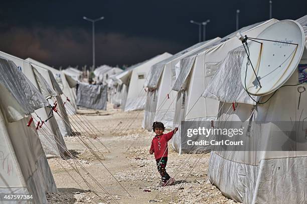 Syrian child walks between tents in Suruc refugee camp on March 25, 2015 in Suruc, Turkey. The camp is the largest of its kind in Turkey with a...