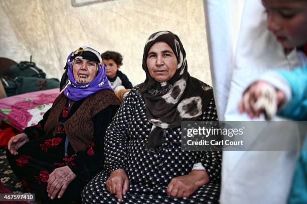 Syrian women sit in their tent in Suruc refugee camp on March 25, 2015 in Suruc, Turkey. The camp is the largest of its kind in Turkey with a...