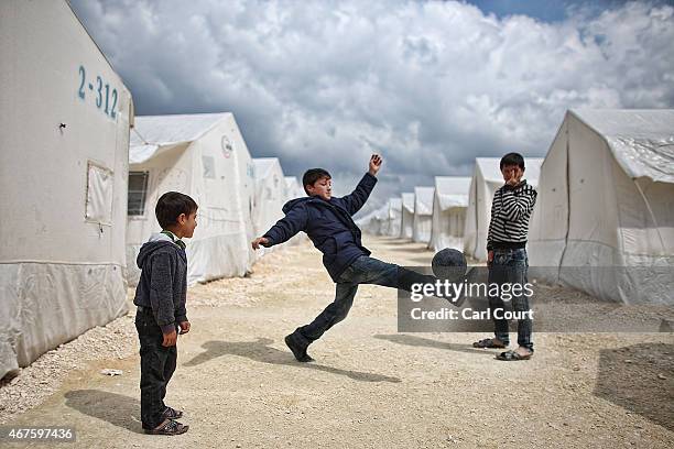 Syrian boys play football in Suruc refugee camp on March 25, 2015 in Suruc, Turkey. The camp is the largest of its kind in Turkey with a population...