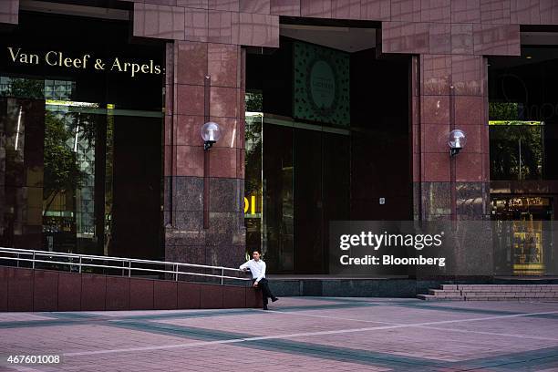 Man sits outside a Van Cleef & Arpels store, a unit of Cie. Financiere Richemont SA, on Orchard Road in Singapore on Wednesday, March 25, 2015. Lee...