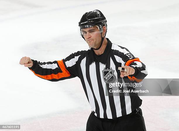 Referee Jean Herbert signals a cross checking penalty on Brian Lashoff of the Detroit Red Wings during third period action against the Florida...