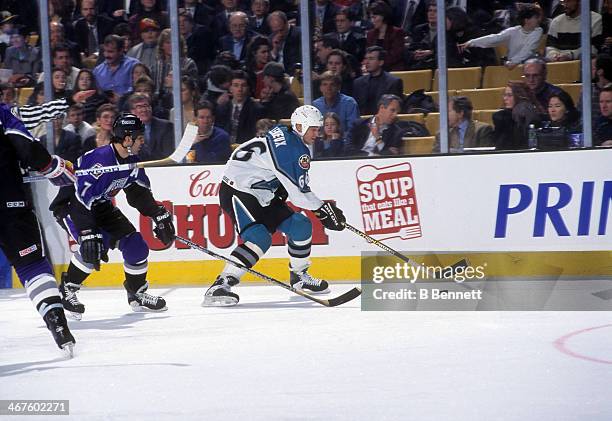 Mario Lemieux of the Eastern Conference and Pittsburgh Penguins skates with the puck as he is defended by Chris Chelios of the Western Conference and...