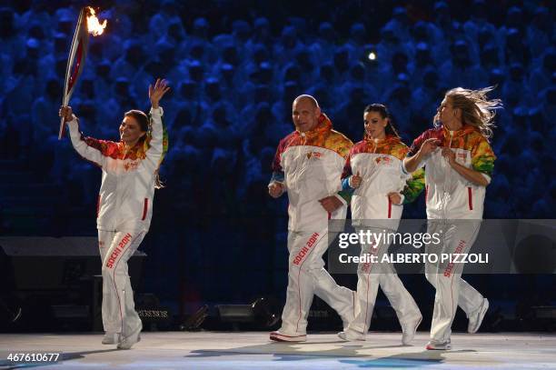 Russian Olympic medalists Alina Kabaeva , Alexander Karelin, Elena Isinbaeva and Maria Sharapova run with the Olympic torch during the Opening...