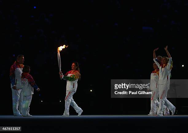 Olympic torch bearer Alina Kabaeva passes the torch to Irina Rodnina and Vladislav Tretyak as Maria Sharapova , Alexandr Karelin and Elena Isinbaeva...