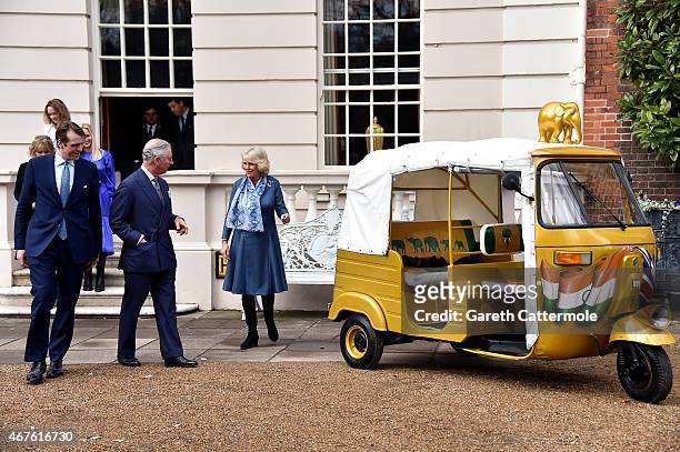 Camilla, Duchess of Cornwall and Prince Charles, Prince of Wales stand next to a rickshaw at Clarence House on March 26, 2015 in London, England. In...