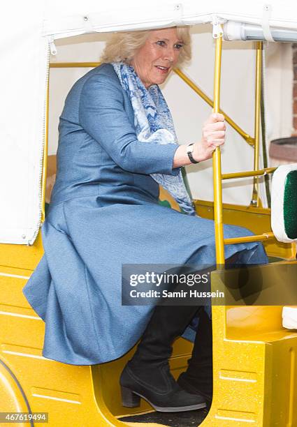 Camilla, Duchess of Cornwall holds on as she rides in a rickshaw as they launch 'Travels to my Elephant' Rickshaw Race at Clarence House on March 26,...