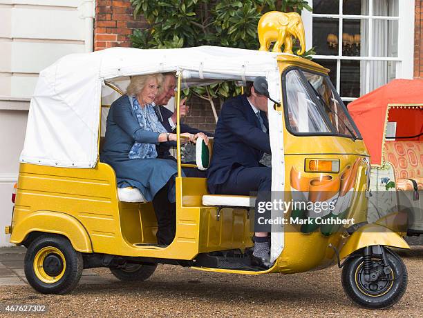 Camilla, Duchess of Cornwall and Prince Charles, Prince of Wales ride in a rickshaw at Clarence House on March 26, 2015 in London, England.