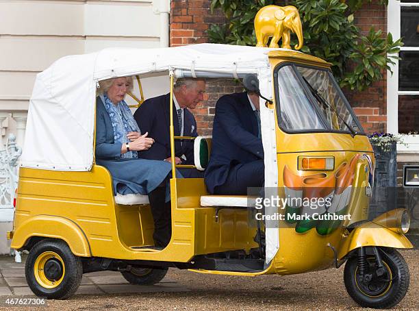 Camilla, Duchess of Cornwall and Prince Charles, Prince of Wales ride in a rickshaw at Clarence House on March 26, 2015 in London, England.