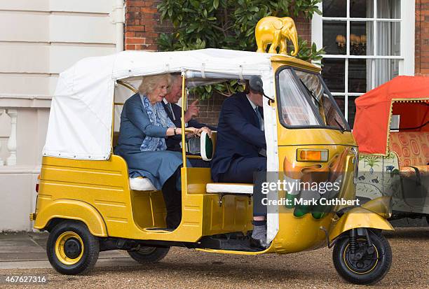 Camilla, Duchess of Cornwall and Prince Charles, Prince of Wales ride in a rickshaw at Clarence House on March 26, 2015 in London, England.