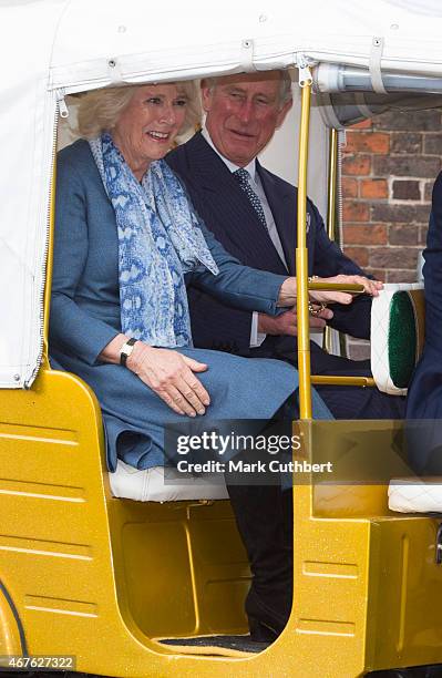 Camilla, Duchess of Cornwall and Prince Charles, Prince of Wales ride in a rickshaw at Clarence House on March 26, 2015 in London, England.