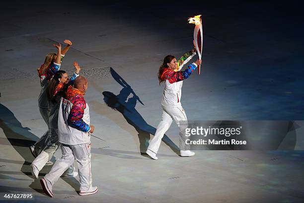 Alina Kabaeva carries the Olympic torch during the Opening Ceremony of the Sochi 2014 Winter Olympics at Fisht Olympic Stadium on February 7, 2014 in...