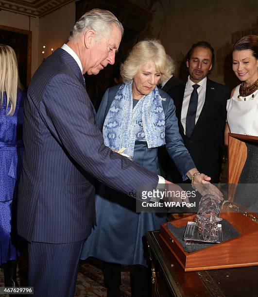 Prince Charles, Prince of Wales and Camilla, Duchess of Cornwall look at a rhinoceros sculpture, The Perfect World Foundation's award for...