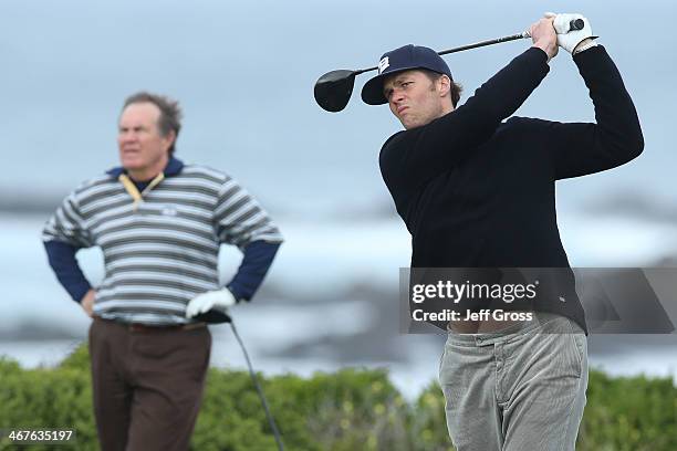 New England Patriots quarterback Tom Brady hits a tee shot on the 13th hole as New England Patriots head coach Bill Belichick looks on during the...