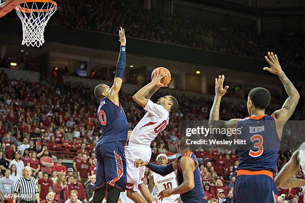 Rashad Madden of the Arkansas Razorbacks goes up for a shot while being defended by Asahun Dixon-Tatum of the Auburn Tigers at Bud Walton Arena on...