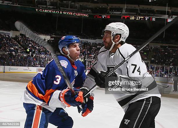 Dwight King of the Los Angeles Kings is checked by Travis Hamonic of the New York Islanders during the first period at the Nassau Veterans Memorial...