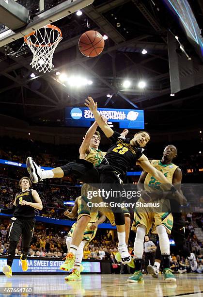 Fred VanVleet of the Wichita State Shockers drives to the basket against Steve Vasturia and Jerian Grant of the Notre Dame Fighting Irish in the...