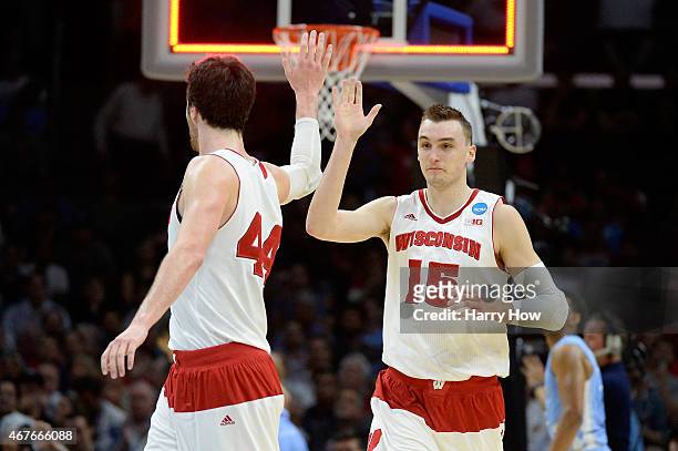 Sam Dekker of the Wisconsin Badgers celebrates with Frank Kaminsky after Dekker scores at the end of the first half against the North Carolina Tar...