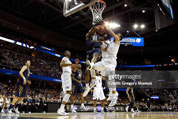 BillyDee Williams of the West Virginia Mountaineers drives to the basket and is blocked by Willie Cauley-Stein and Trey Lyles of the Kentucky...