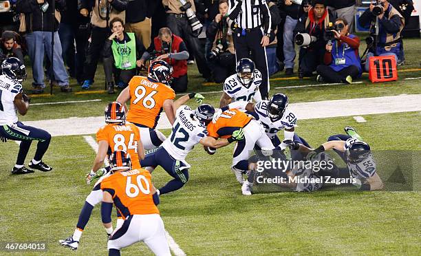 Trindon Holliday of the Denver Broncos gets swarmed by the Seattle Seahawks on the opening kickoff during Super Bowl XLVIII against at MetLife...