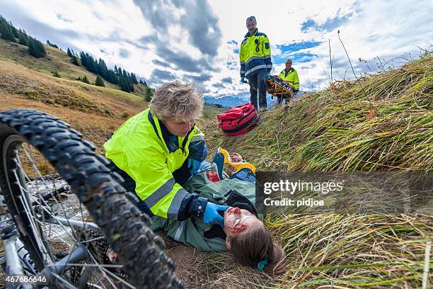 rescue workers in action to rescue mountain bike accident victim - casualty stock pictures, royalty-free photos & images