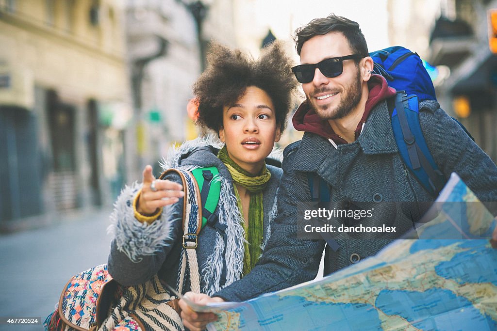 Backpakers in the city checking map