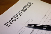 Pen lies over eviction notice paper to fill