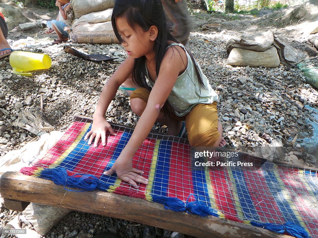 A young girl fixing the 'karawan'. Karawan is a manual...