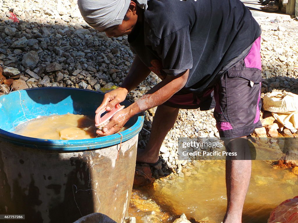 A miner sorting out stones with possible gold minerals in it...