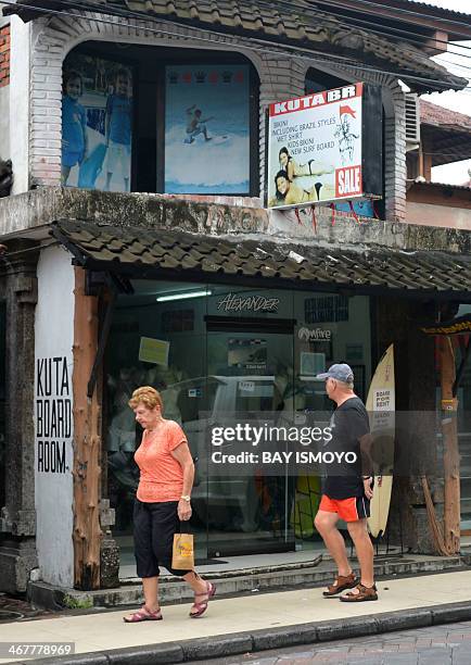 Foreign tourists walk past Australian drug trafficker Schapelle Corby's sister, Mercedes Corby, surfing and bikini shop, in Kuta, on February 8,...