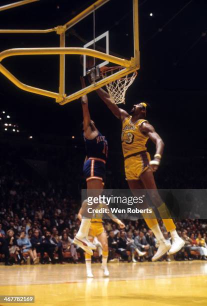 Wilt Chamberlain of the Los Angeles Lakers looks to block the shot attempt of Walt Frazier of the New York Knicks during the 1971-1972 season at the...