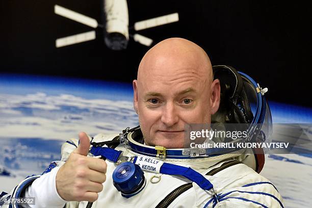 Astronaut Scott Kelly gestures as his space suit is tested at the Russian-leased Baikonur cosmodrome, prior to blasting off to the International...