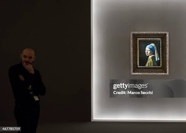 Member of staff stands next to Vermeer's "La ragazza con l'orecchino di perla" at Palazzo Fava on February 8, 2014 in Bologna, Italy. The exhibition...