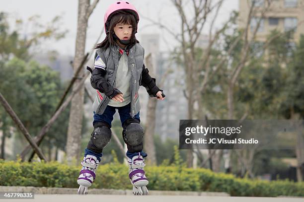 little girl roller skating - kniebeschermer stockfoto's en -beelden