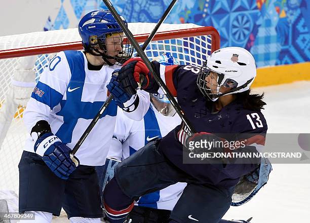 Finland's Tea Villila vies with US Julie Chu during their Women's Ice Hockey Group A match at the Shayba Arena during the Sochi Winter Olympics on...