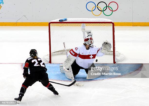 Hayley Wickenheiser of Canada scores a goal against Florence Schelling of Switzerland in the second period during the Women's Ice Hockey Preliminary...