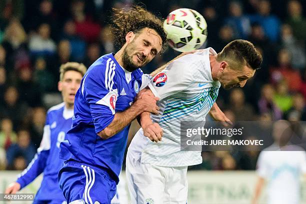 Slovenia's midfielder Andraz Kirm heads the ball with San Marino's Alessandro Della Valle during the Euro 2016 qualifying group E football match...