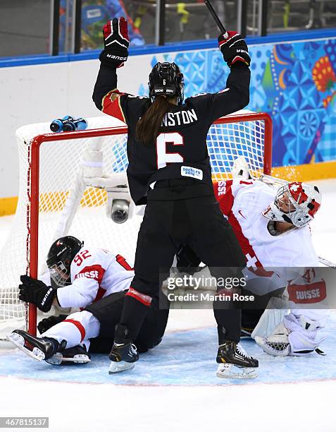 Rebecca Johnston of Canada scores a goal against Florence Schelling and Sandra Thalmann of Switzerland in the second period during the Women's Ice...