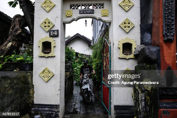 Man rides a motorcycle out of a house where Australian drug trafficker Schapelle Corby's sister and brother in law, Mercedes Corby and Wayan...