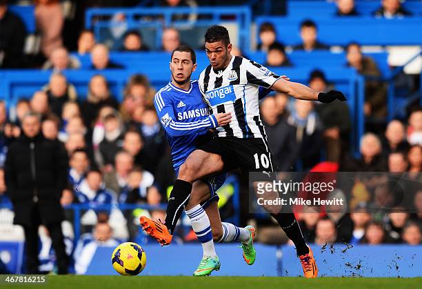 Eden Hazard of Chelsea and Hatem Ben Arfa of Newcastle United challenge for the ball during the Barclays Premier League match between Cheslea and...