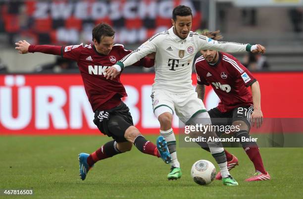 Marvin Plattenhardt and Markus Feulner of Nuernberg fight for the ball with Thiago of Muenchen during the Bundesliga match between 1. FC Nuernberg...