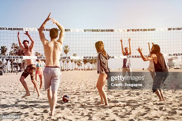 people playing beach volleyball - beach volleyball stockfoto's en -beelden