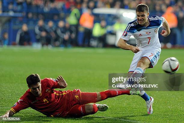 Russia's Igor Denisov challenges Montenegro's Nikola Vukcevic during the Euro 2016 group G qualifying football match between Montenegro and Russia at...