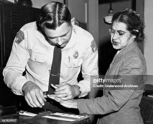 American civil rights activist, Rosa Parks is fingerprinted by Lieutenant DH Lackey in Montgomery, Alabama, after she was arrested during the...