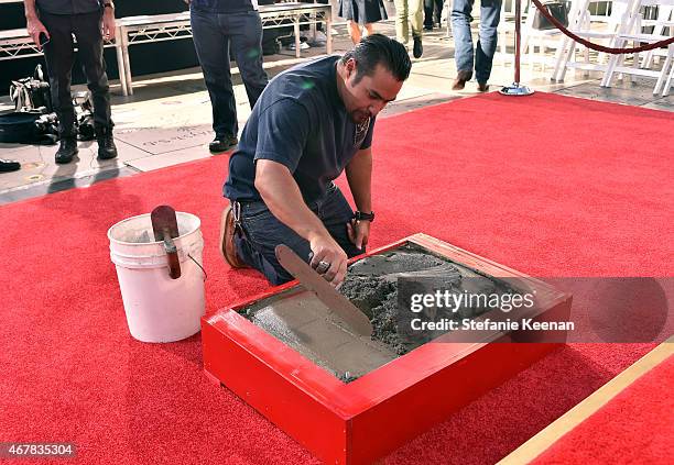 Worker preps the cement for the Christopher Plummer Hand and Footprint Ceremony during the 2015 TCM Classic Film Festival on March 27, 2015 in Los...